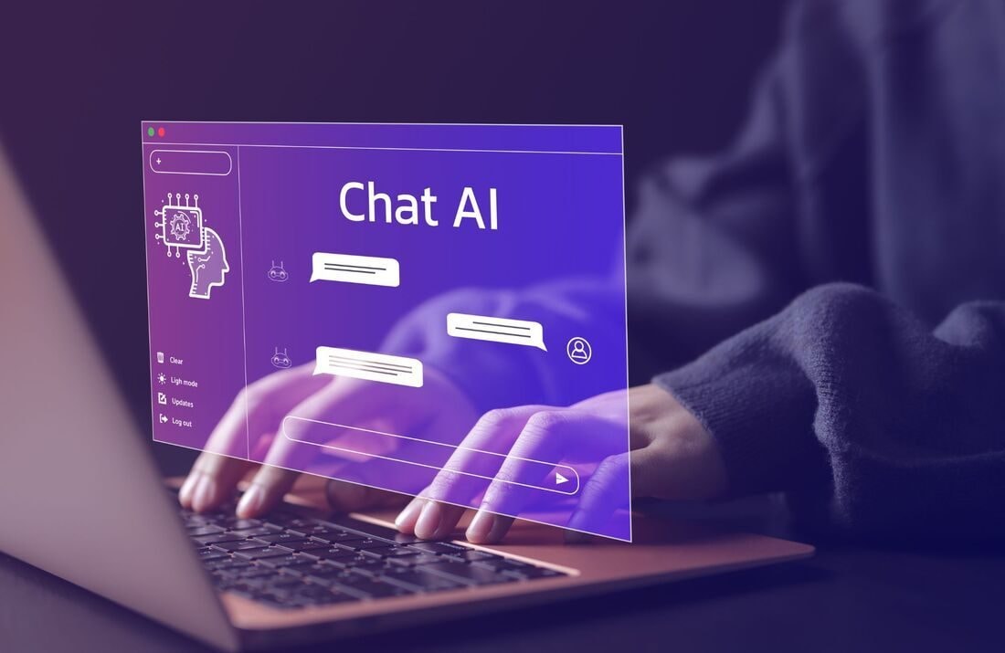 Hands typing on a laptop with a glowing AI chat window floating above the keyboard