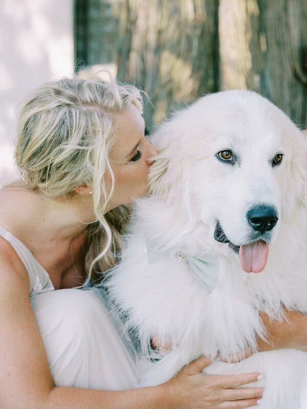 Jessica hugging the family's big, fluffy Great Pyrenees